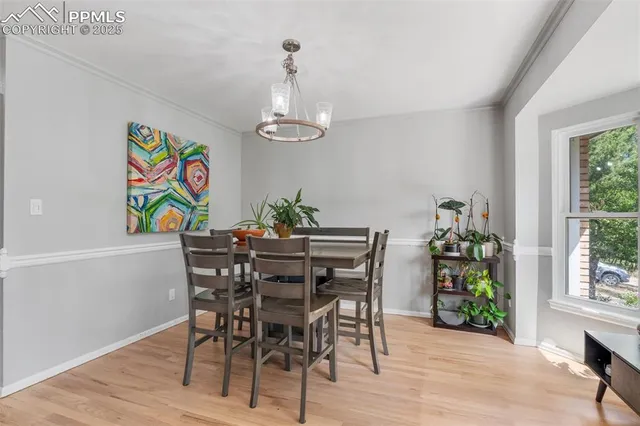 a view of a dining room with furniture one side kitchen view and wooden floor