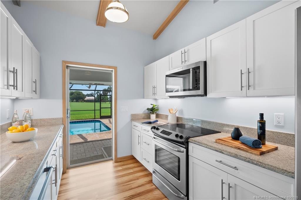 3453 Southeast Fairway East Stuart, FL 34997 - Photo 15 of 43 a kitchen with stainless steel appliances granite countertop a stove a sink and a microwave