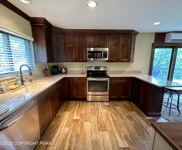 a kitchen with a sink a window stainless steel appliances and cabinets