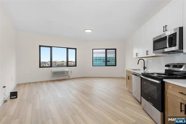 a view of a kitchen with wooden floor and stainless steel appliances