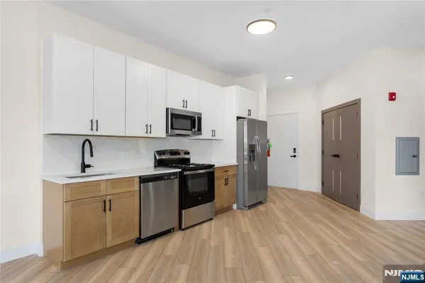 a kitchen with a sink a refrigerator and cabinets