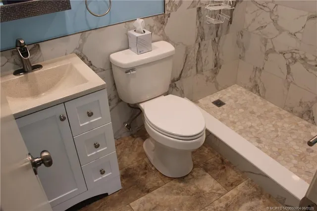a white toilet sitting next to a bathroom sink