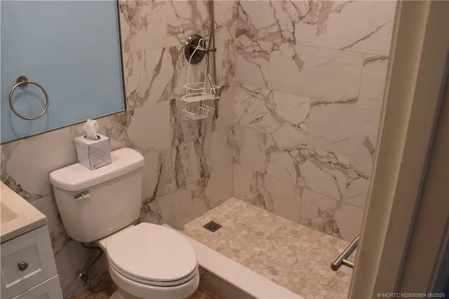 a white toilet sitting next to a bathroom sink