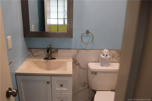 a bathroom with a toilet sink and mirror