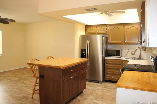 a kitchen with stainless steel appliances granite countertop a sink and a refrigerator