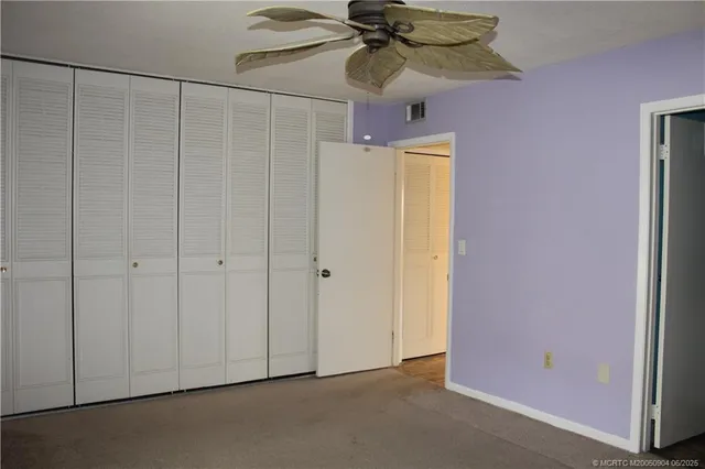 a view of a room with a chandelier fan