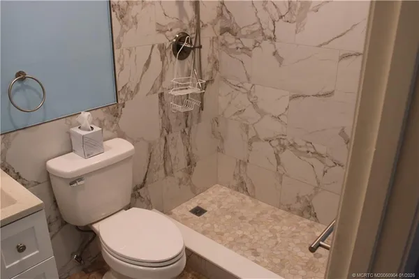 a white toilet sitting next to a bathroom sink