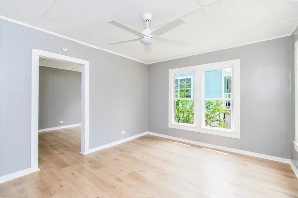 an empty room with windows and ceiling fan