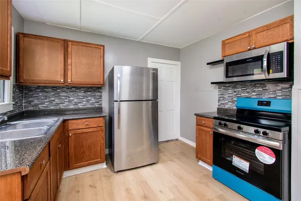 a kitchen with stainless steel appliances granite countertop a refrigerator stove and sink