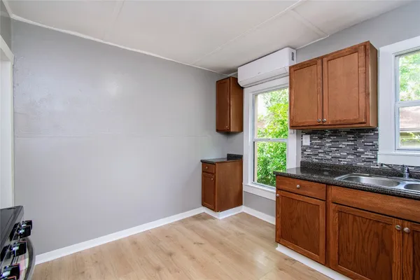 a kitchen with granite countertop cabinets stainless steel appliances a sink and a window