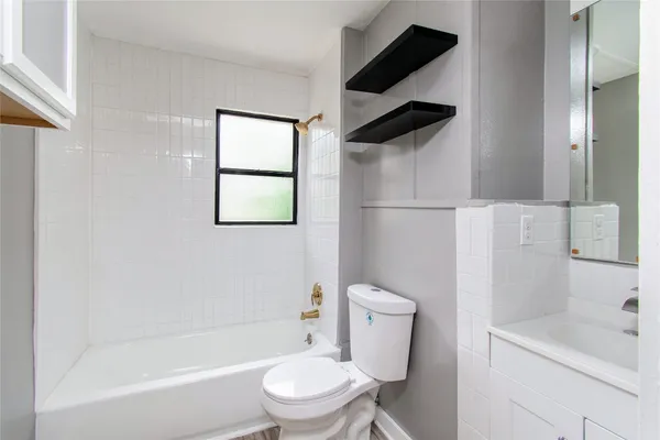 a white toilet sitting next to a bath tub