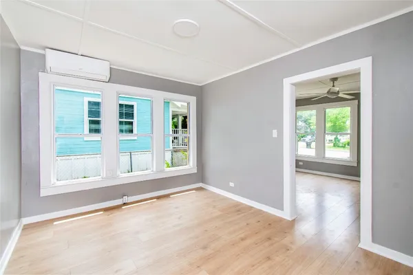 an empty room with wooden floor and windows