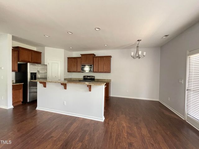 a view of a kitchen with wooden floor and electronic appliances