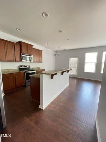 a kitchen with stainless steel appliances granite countertop a stove top oven a sink dishwasher and a microwave oven on the blue kitchen countertops with wooden floor
