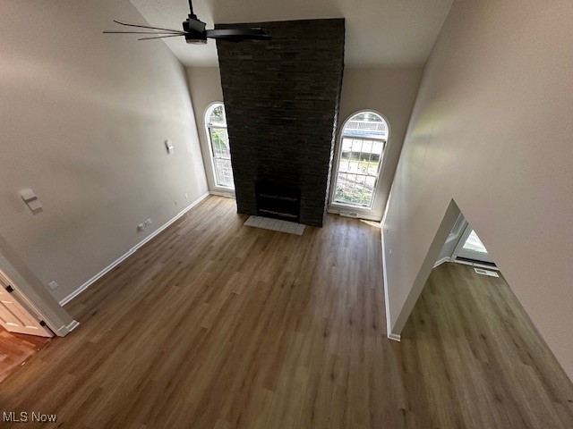 12470 Caves Road Chesterland, OH 44026 - Photo 10 of 24 Unfurnished living room with wood finished floors, high vaulted ceiling, a fireplace, and ceiling fan