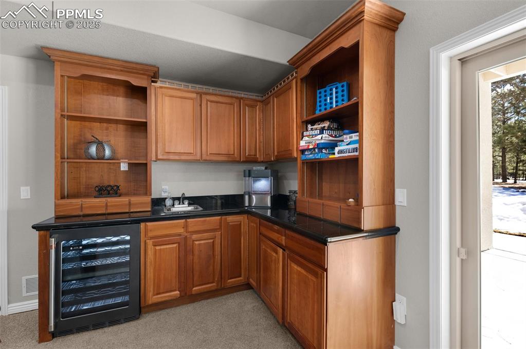 17502 Abert Ridge View Colorado Springs, CO 80908 - Photo 33 of 50 Bar with a sink, wine cooler, and light carpet