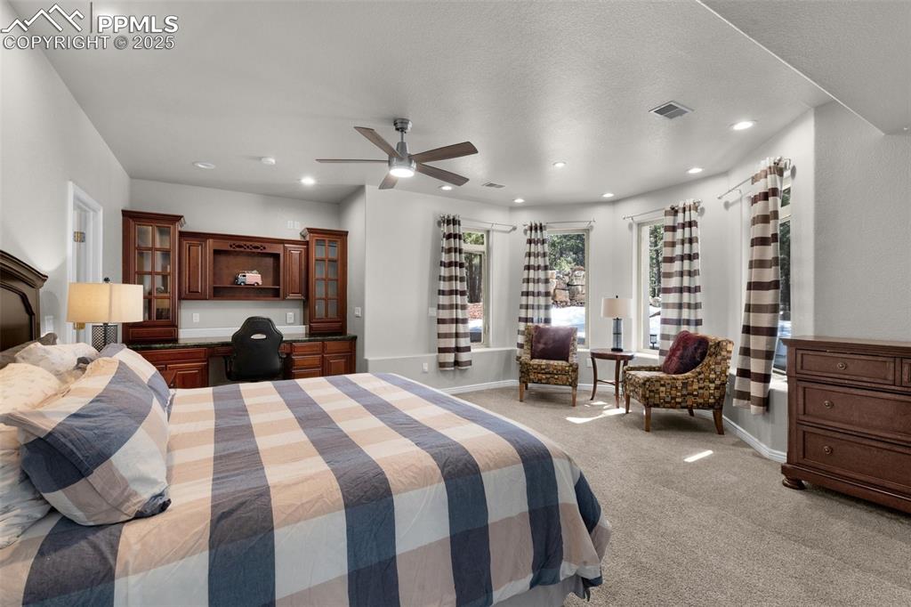 17502 Abert Ridge View Colorado Springs, CO 80908 - Photo 35 of 50 Bedroom with a ceiling fan, baseboards, built in study area, recessed lighting, and light carpet