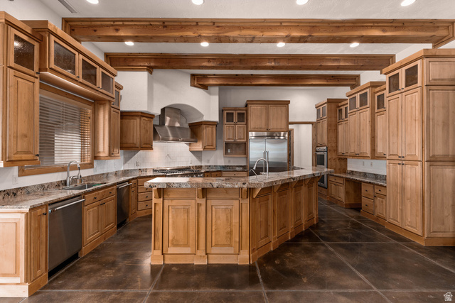 2464 East Granite Way St. George, UT 84790 - Photo 46 of 106 Kitchen featuring glass insert cabinets, tasteful backsplash, dark stone counters, beam ceiling, and stainless steel appliances