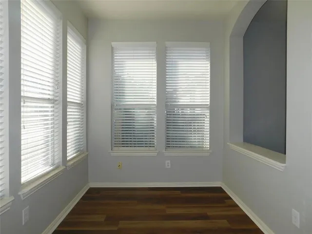an empty room with closet and windows