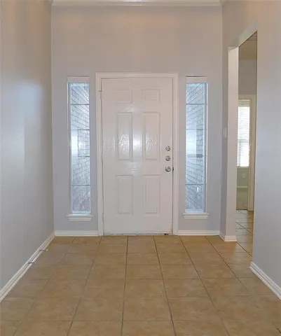 an empty room with wooden floor chandelier fan and windows