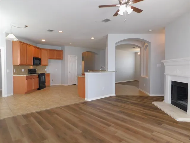 a kitchen with stainless steel appliances granite countertop a stove top oven a sink a refrigerator and cabinets