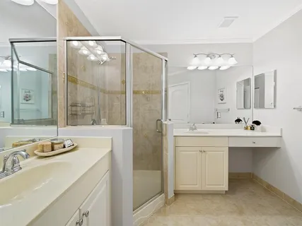 a bathroom with a double vanity sink mirror and shower