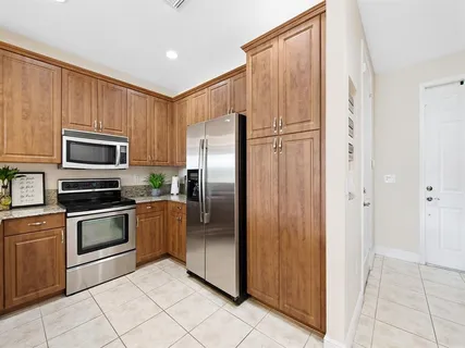 a kitchen with stainless steel appliances granite countertop a refrigerator and a stove top oven