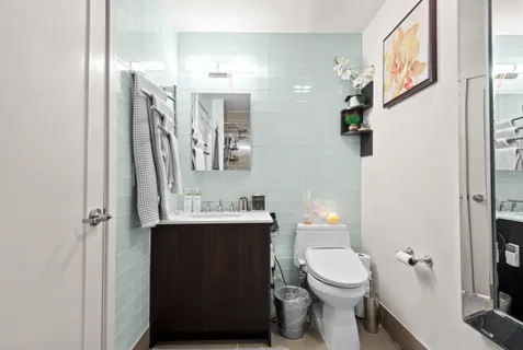 a bathroom with a toilet a sink and mirror