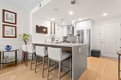 a kitchen with stainless steel appliances kitchen island granite countertop a refrigerator and a stove top oven