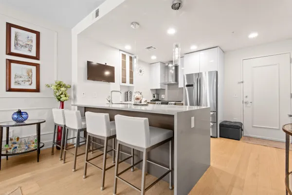 a kitchen with stainless steel appliances kitchen island granite countertop a refrigerator and a stove top oven