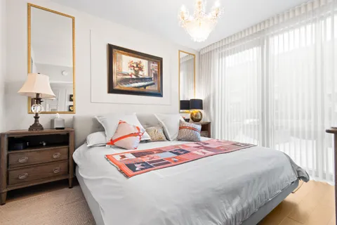 a bedroom with a bed and a lamp on dresser