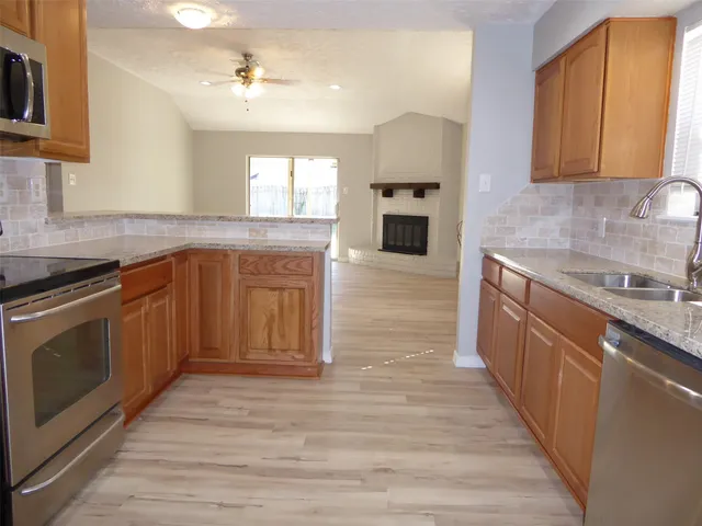a kitchen with stainless steel appliances granite countertop a stove a sink and a microwave