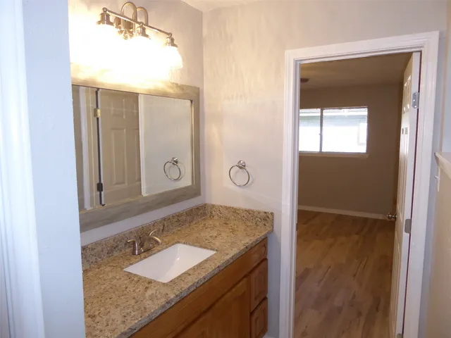 a bathroom with a granite countertop sink and a mirror