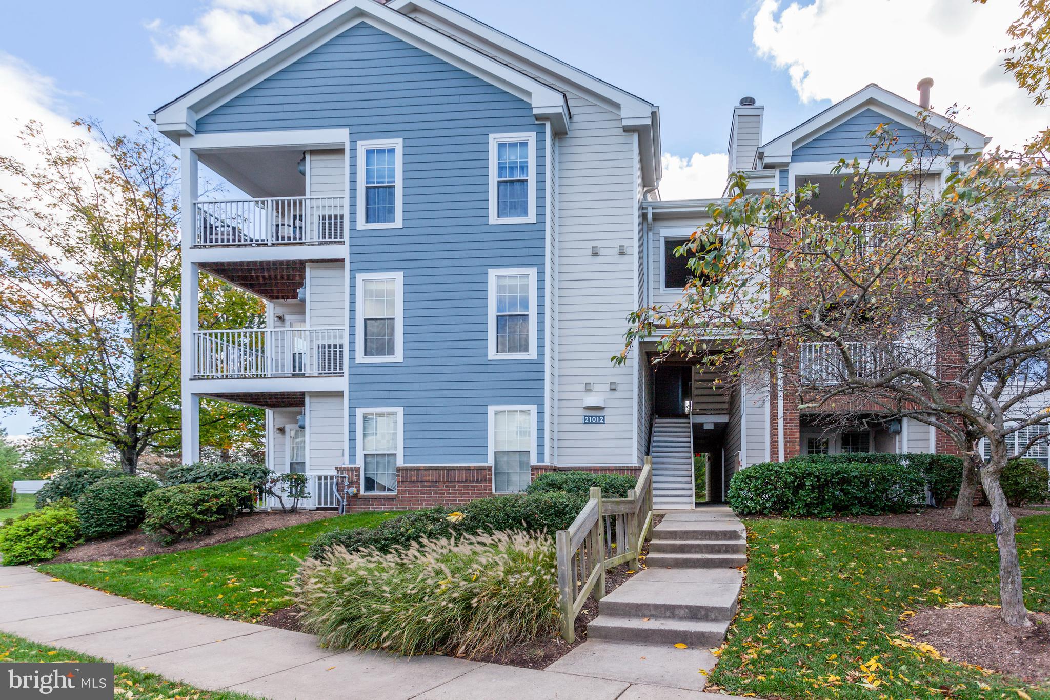 21012 Timber Ridge Terrace, Unit 201 Ashburn, VA 20147 - Photo 1 of 37 a front view of a house with garden