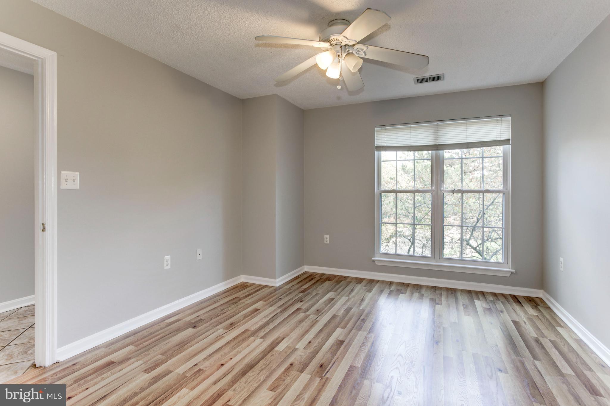 21012 Timber Ridge Terrace, Unit 201 Ashburn, VA 20147 - Photo 13 of 37 wooden floor in an empty room with a window