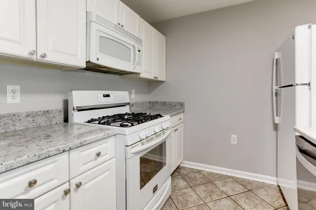 a kitchen with granite countertop cabinets stainless steel appliances and a sink
