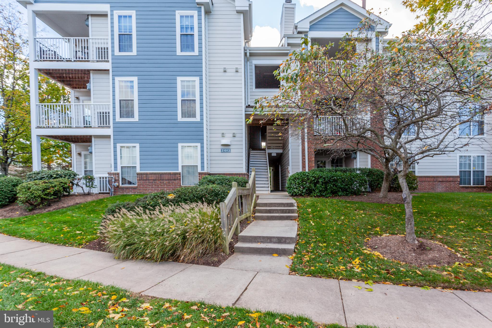 21012 Timber Ridge Terrace, Unit 201 Ashburn, VA 20147 - Photo 2 of 37 a front view of a house with garden