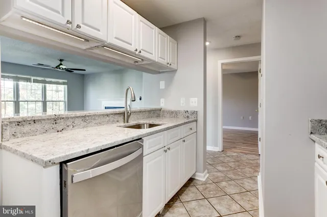 a kitchen with granite countertop a sink and cabinets