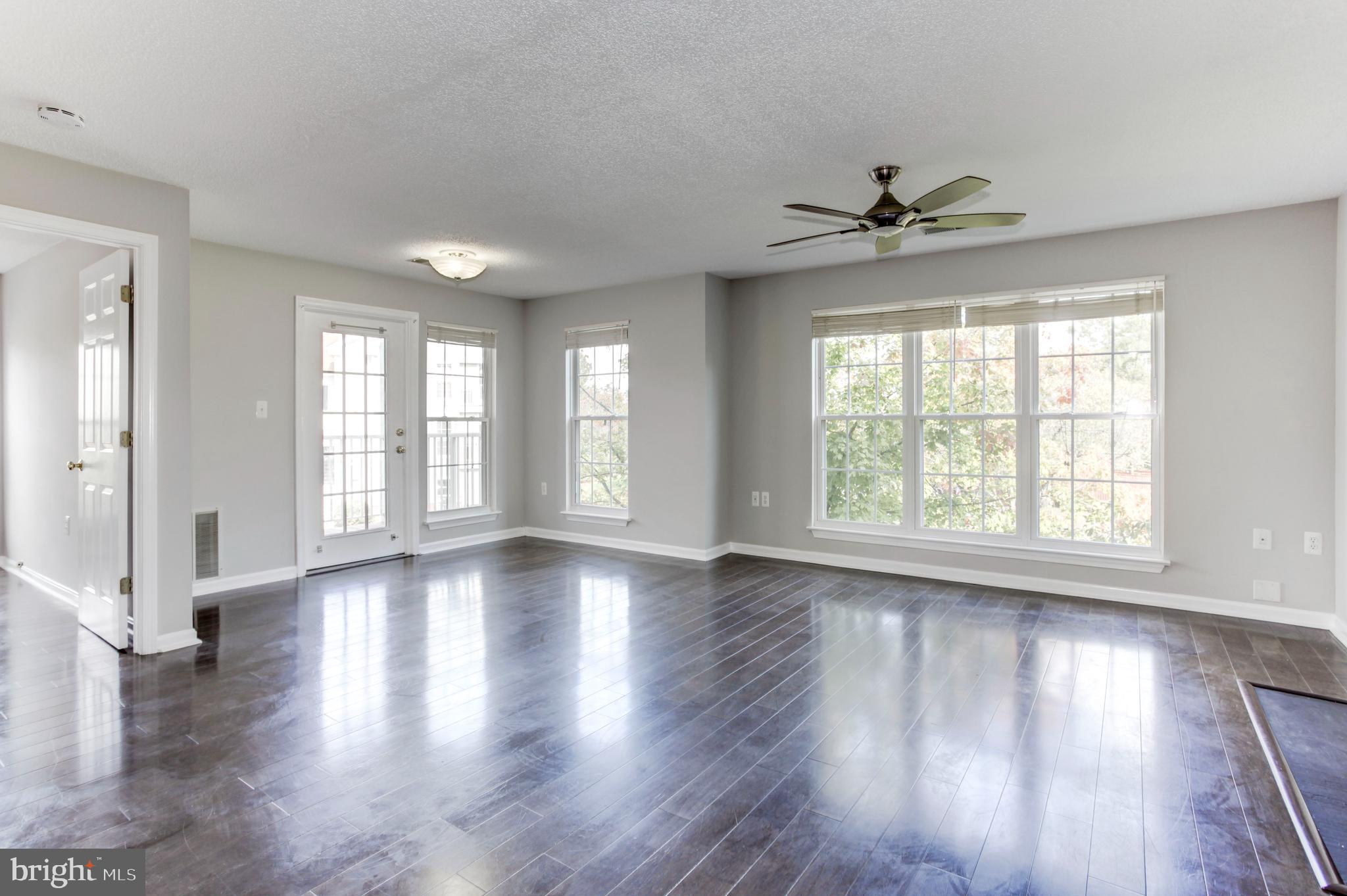 21012 Timber Ridge Terrace, Unit 201 Ashburn, VA 20147 - Photo 22 of 37 a view of an empty room with wooden floor and a window