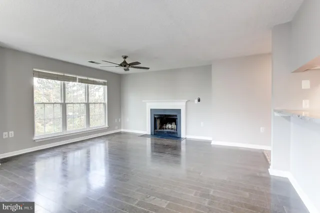 a view of an empty room with a window and fireplace