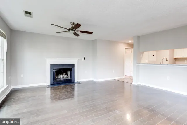 a view of an empty room with a fireplace and a window