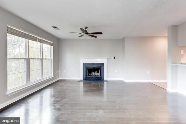 an empty room with windows and a fireplace