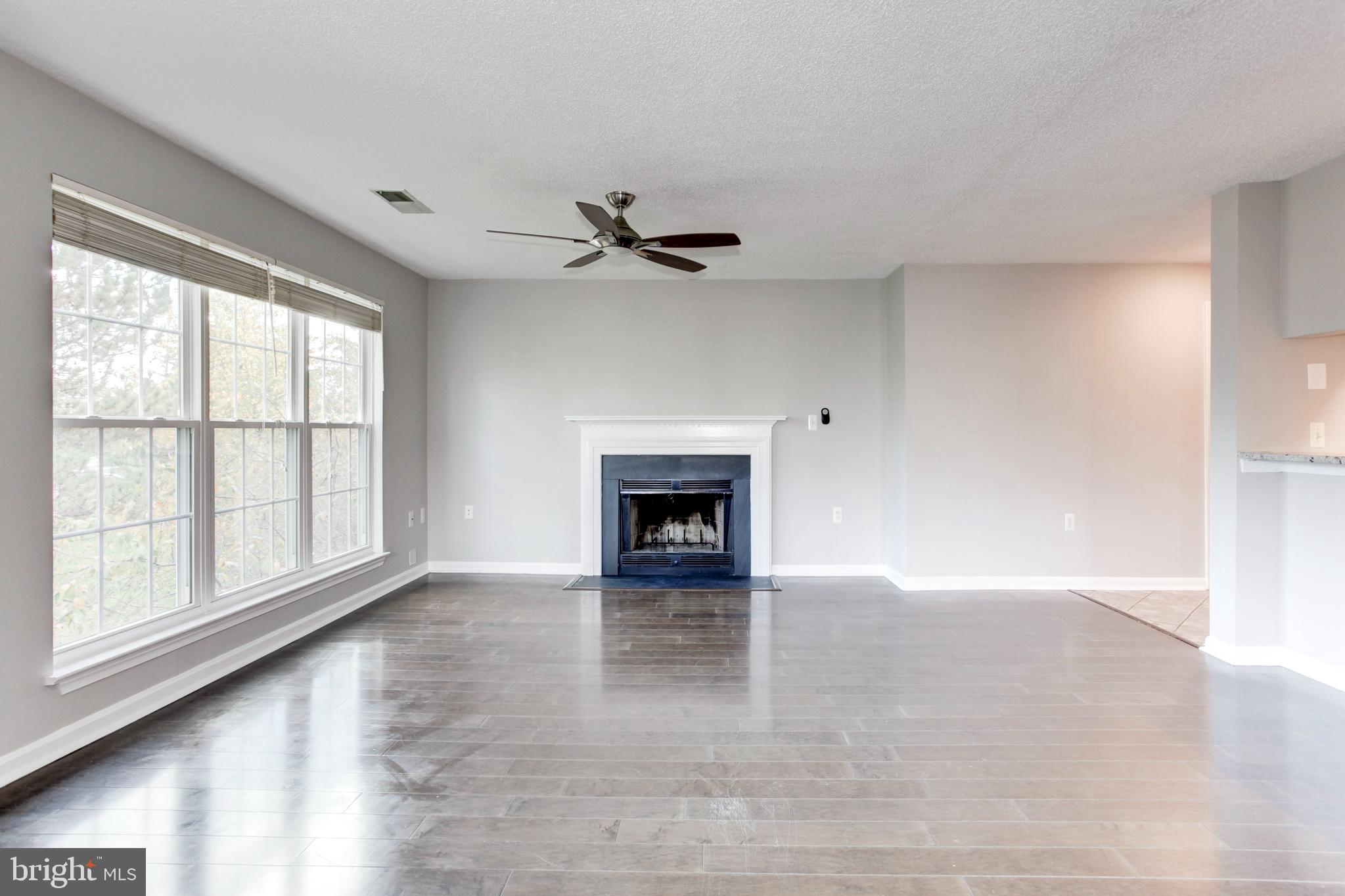 21012 Timber Ridge Terrace, Unit 201 Ashburn, VA 20147 - Photo 25 of 37 an empty room with windows and a fireplace