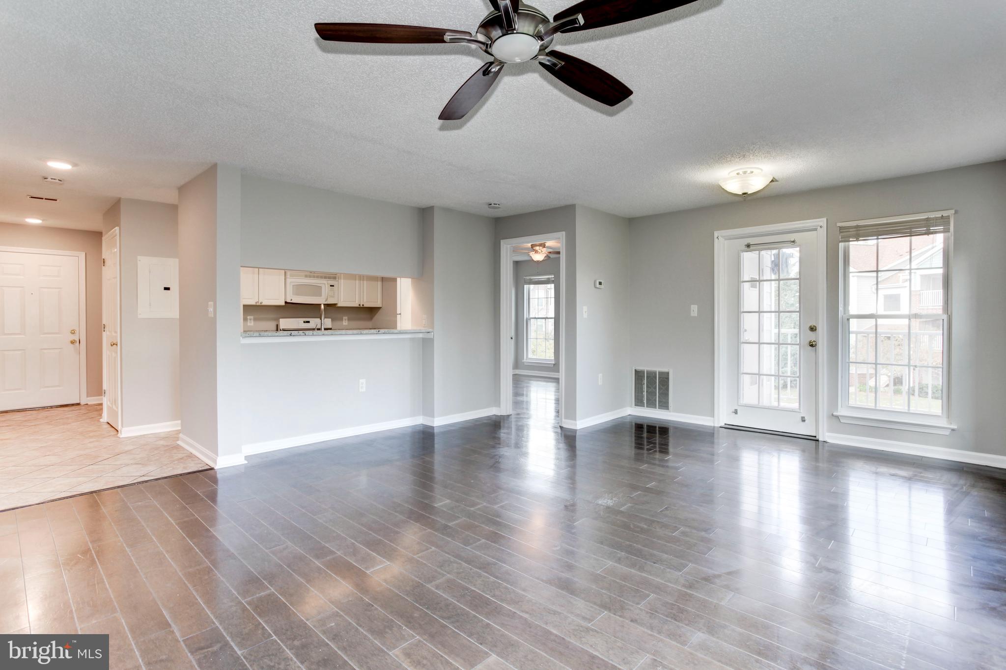 21012 Timber Ridge Terrace, Unit 201 Ashburn, VA 20147 - Photo 26 of 37 a view of an empty room with window and wooden floor