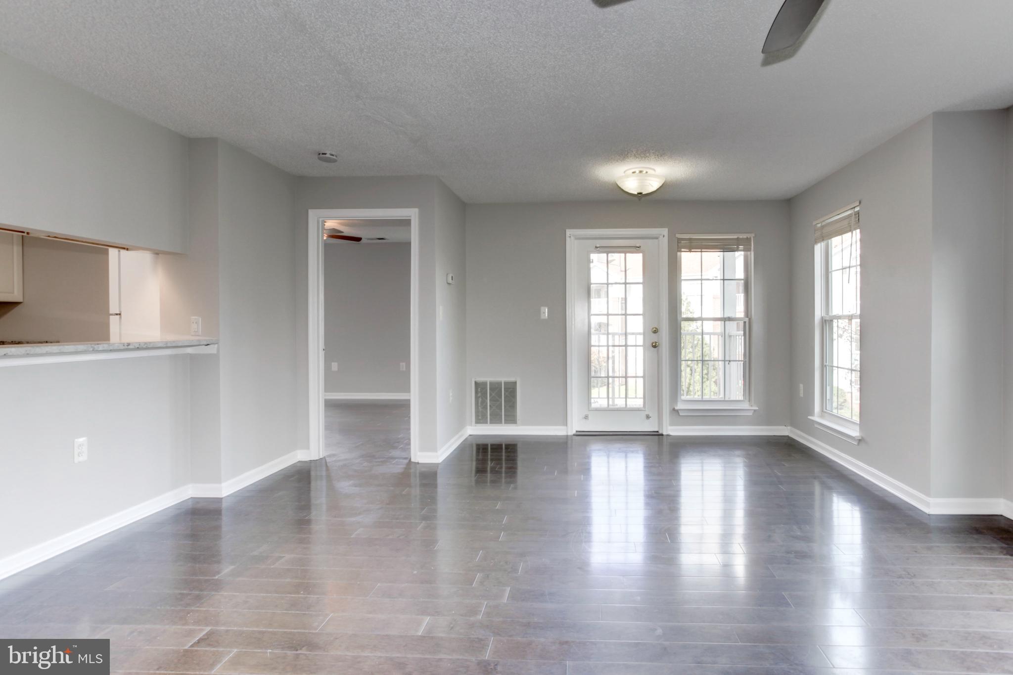 21012 Timber Ridge Terrace, Unit 201 Ashburn, VA 20147 - Photo 27 of 37 an empty room with wooden floor and windows