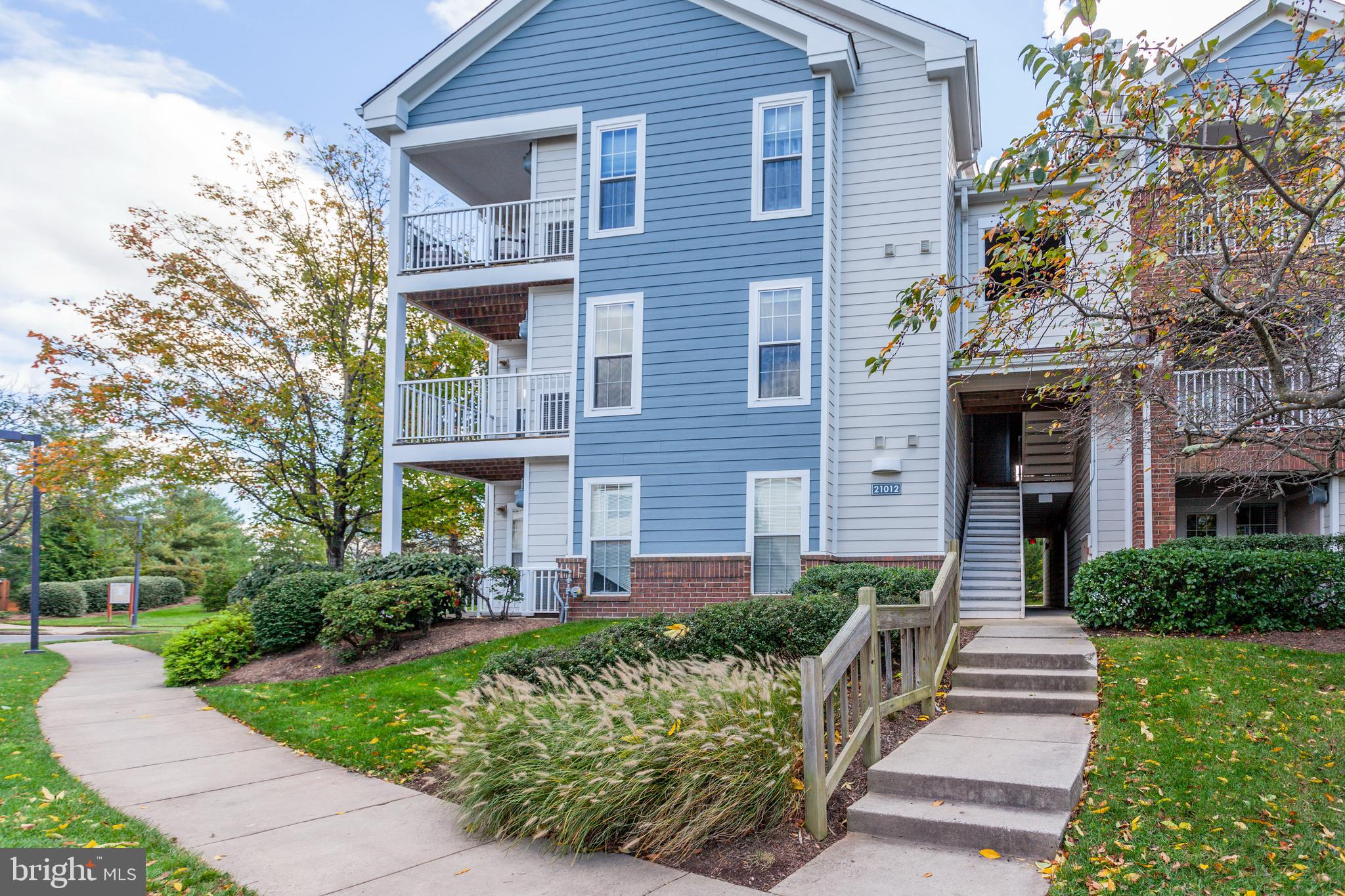 21012 Timber Ridge Terrace, Unit 201 Ashburn, VA 20147 - Photo 3 of 37 a front view of a house with a yard