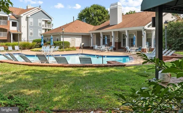a view of a white house with a large pool table and chairs