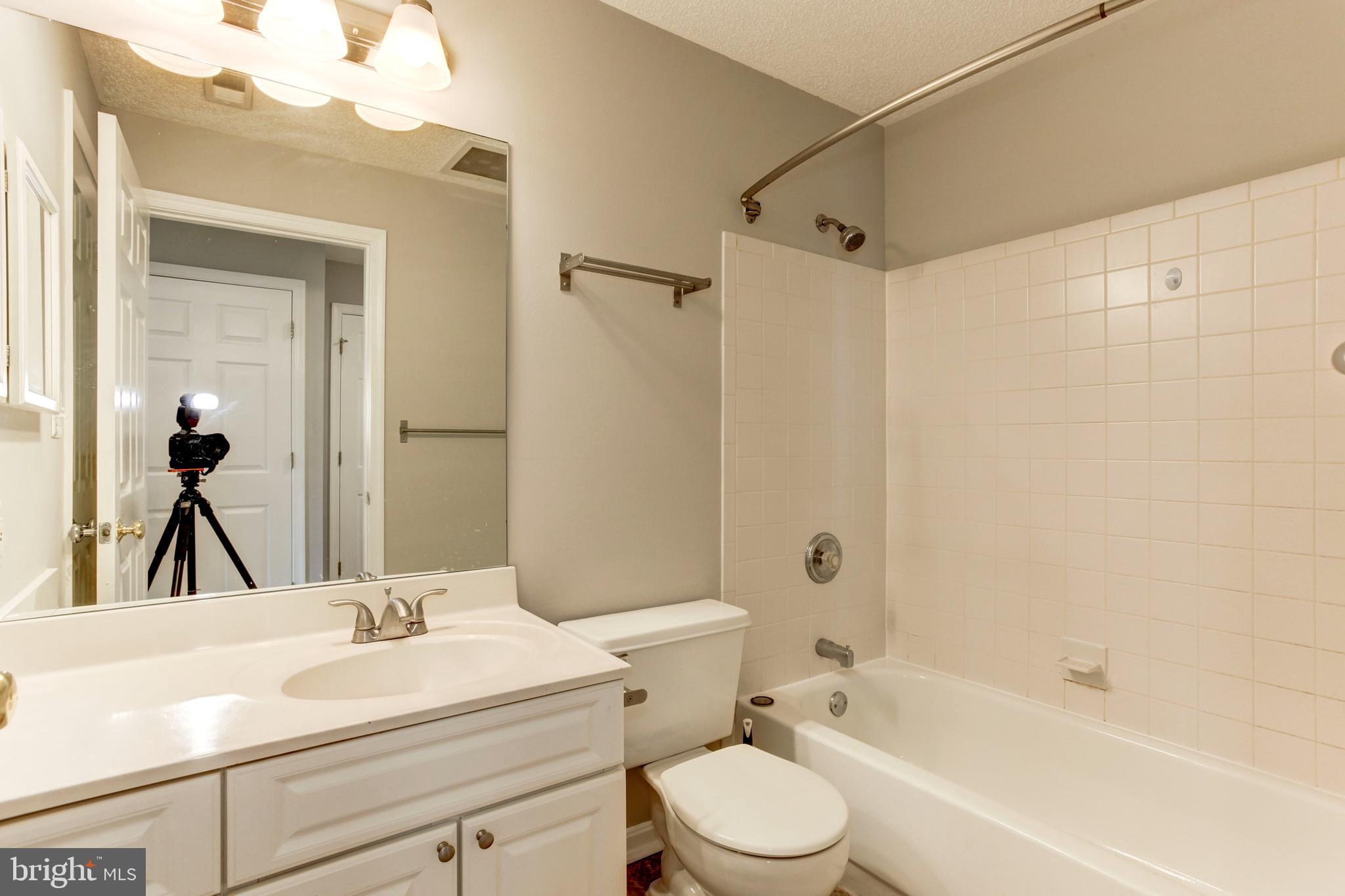 21012 Timber Ridge Terrace, Unit 201 Ashburn, VA 20147 - Photo 8 of 37 a bathroom with a sink a toilet and shower