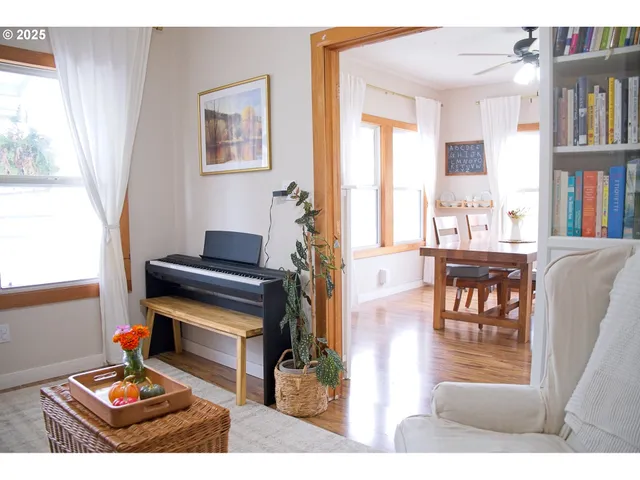 a living room with furniture and a piano next to a large window