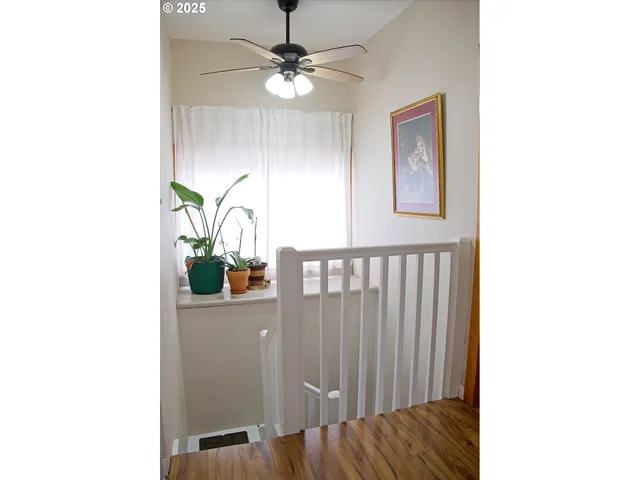 a view of a hallway with wooden floor and dining room